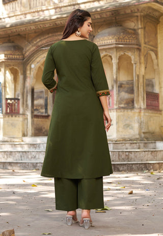 Woman in a green traditional outfit standing in an architectural setting