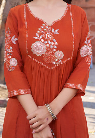 Red embroidered dress with floral patterns on a blurred background
